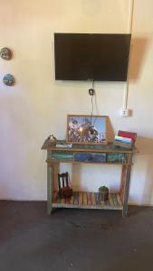 een tafel met een televisie op een muur bij HOSTEL DA LÚ in Pirenópolis