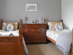 a bedroom with two twin beds and a dresser at Porthysgaden in Twdweiliog