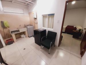 Apartamento en centro de Popayán في بوبايان: حمام مع كرسي ومغسلة في الغرفة