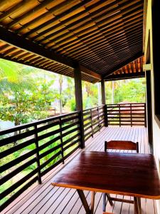 un tavolo in legno su una veranda con panchina di Turtle Bay Village a São Miguel do Gostoso
