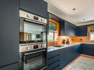 a kitchen with blue cabinets and a stove at Copper House in Willoughby