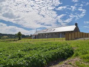 a barn on a farm with a field of crops at Bwthyn Y Bugail in Abercych