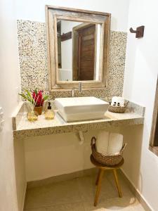 uma casa de banho com um lavatório branco e um espelho. em Casa Roure Pousada em Trancoso