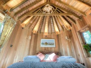 a bedroom in a tiny house with a wooden ceiling at Trewalter Treehouse in Brecon