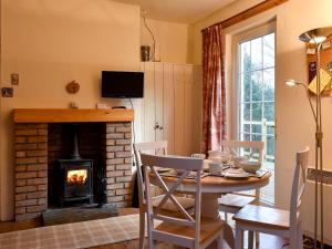 a dining room with a table and a fireplace at The Creagan in Corrie