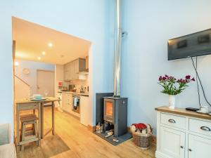 a kitchen and living room with a wood stove at Island Views in Lagganulva