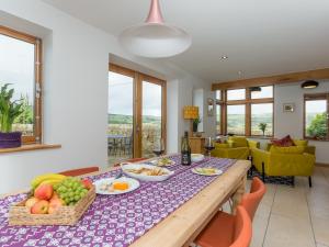 Sands Farm Cottage في Luddenden Foot: غرفة طعام مع طاولة مع فاكهة عليها