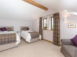 Sands Farm Cottage في Luddenden Foot: غرفة نوم بسريرين واريكة