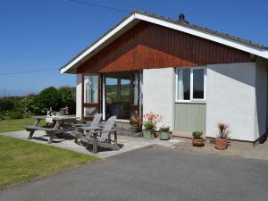 a house with a picnic table and chairs in front of it at Seafield in Llanrhyddlad