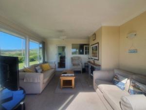 a living room with two couches and a tv at Seafield in Llanrhyddlad