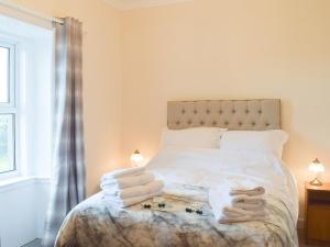 a bedroom with a bed with towels on it at Ardlochan Cottage in Maidens