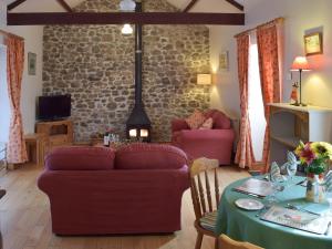 sala de estar con 2 sofás y mesa con mantel en Gwili Cottage, en Llanfynydd