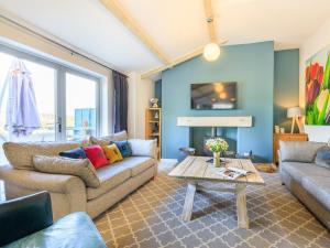 a living room with a couch and a table at The Cow Shed in Buckland St Mary