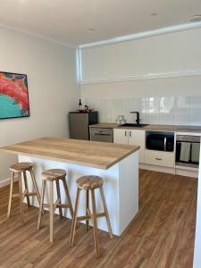 a kitchen with a counter and stools in it at Harbour View Motel in Robe