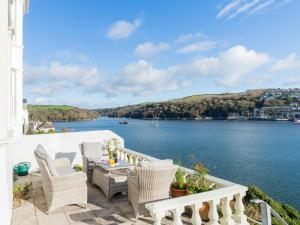 a balcony with chairs and a view of the water at Apartment 2 The Wheelhouse in Fowey