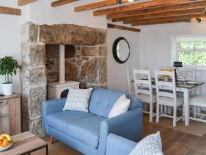 a living room with a blue couch and a table at Bryn Awel in Moelfre