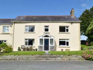 una casa blanca con una puerta negra en The Farmhouse - Uk13183, en Cwm-Morgan