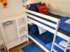 - une chambre avec des lits superposés et des draps bleus dans l'établissement Sandhills, à Sea Palling
