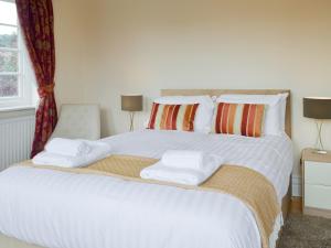 a bedroom with a large white bed with towels on it at The Arches in Scarborough