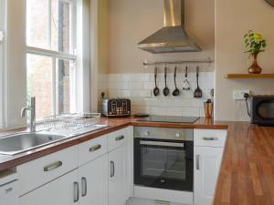 a kitchen with white cabinets and a sink and a window at The Arches in Scarborough