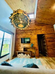 une chambre avec un mur en bois avec un lustre dans l'établissement Rümü, à Pucón 18 autres photos