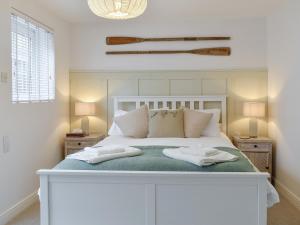 a bedroom with a white bed with two towels on it at Sandgate Apartment in Sandgate