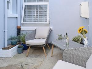 een witte stoel en een tafel op een patio bij Sandgate Apartment in Sandgate