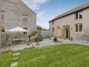 um quintal com uma mesa e um guarda-chuva em Applebarn - Uk10654 em West Pennard