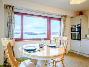 a kitchen and dining room with a table and a window at Riof Bay - Uk31251 in Valtos