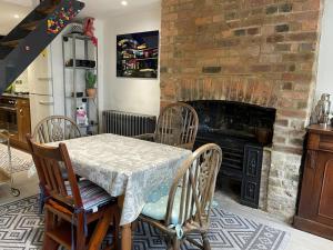 a dining room with a table and a fireplace at Jacks House in Hastings