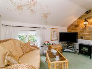 a living room with a couch and a tv at The Garden House-uk11837 in Dronfield