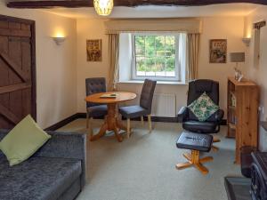 a living room with a couch and a table and chairs at Drumlins Cottage in Gatebeck