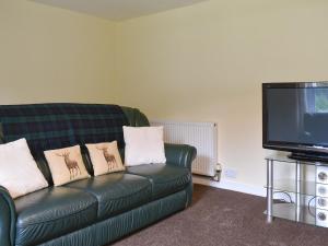 a living room with a couch and a tv at Ben View in Orbliston