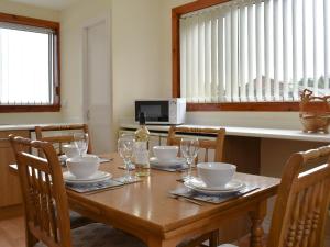 a dining room table with glasses and a bottle of wine at Ben View in Orbliston