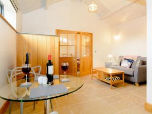 a living room with a table with two glasses of wine at Bluebell Barn - Uk12792 in Royal Wootton Bassett
