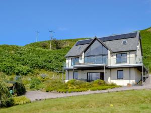 a house with solar panels on the side of a hill at Sealladh Na Mara in Arduaine