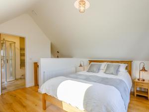 a white bedroom with a large bed with white sheets at Knoll Cottage - Uk31171 in Brent Knoll