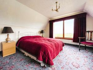 a bedroom with a red bed and a window at Fourpenny Cottage - Uk34744 in Embo