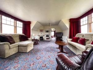 a living room with two couches and a table at Fourpenny Cottage - Uk34744 in Embo