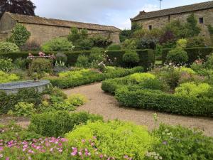 a garden with a bench and many bushes and flowers at The Dovecote in Birstwith