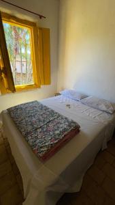 een bed in een slaapkamer met een deken erop bij HOSTEL DA LÚ in Pirenópolis