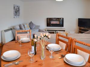a dining room table with plates and wine glasses on it at Glen Apartment in Aviemore