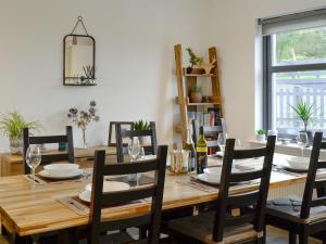 a dining room table with chairs and a wooden table with plates at Thistlebank in Banknock