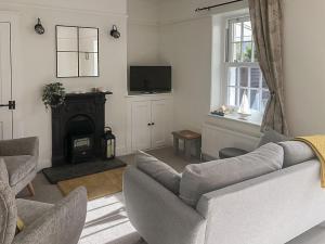 a living room with a couch and a fireplace at Pebble Cottage in Felpham