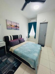 Schlafzimmer mit einem Bett mit blauer Decke in der Unterkunft Insyirah Homestay Melaka in Malakka