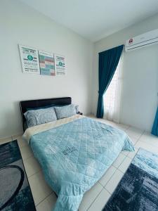 a bedroom with a bed with a blue comforter at Insyirah Homestay Melaka in Melaka