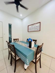 une salle à manger avec une table bleue et des chaises dans l'établissement Insyirah Homestay Melaka, à Malacca