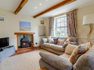 a living room with a couch and a fireplace at 42 Temple End in Blakeney