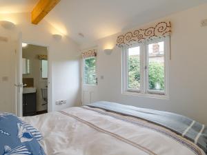 a bedroom with a bed and a window at 42 Temple End in Blakeney