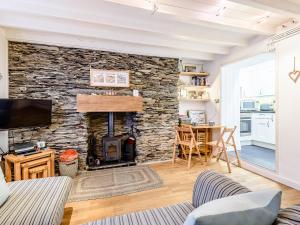 a living room with a stone wall with a fireplace at Pebble Cottage - Uk32243 in Aberdyfi